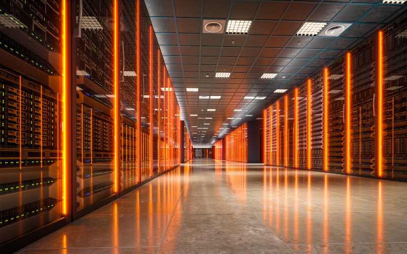A hallway in a data centre with rows of glowing orange server racks
