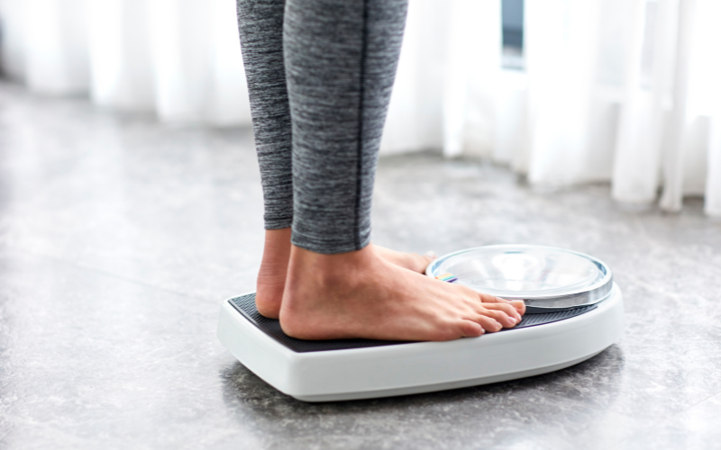 A person stands on a weighing scale