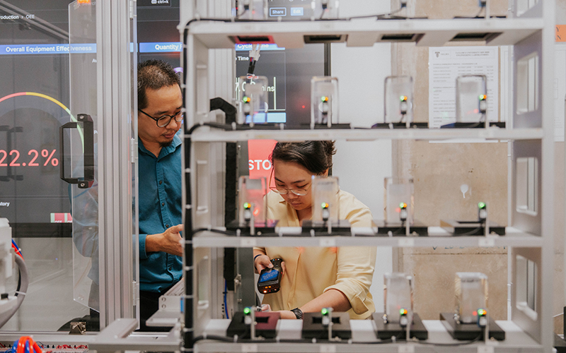 Dr Ng Oon-Ee, Senior Lecturer at the School of Engineering demonstrates real-world problem-solving with Smart Flexible Manufacturing Systems at the Automation Lab, showcasing manufacturing solutions in factories, integrating top-floor and shop-floor operations in a single space.
