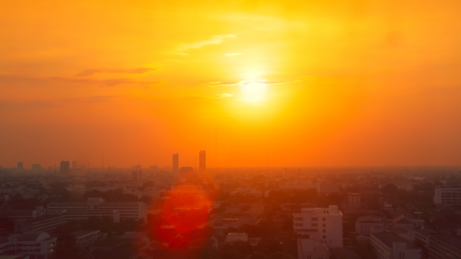 The sun casting a golden glow over a city's skyline