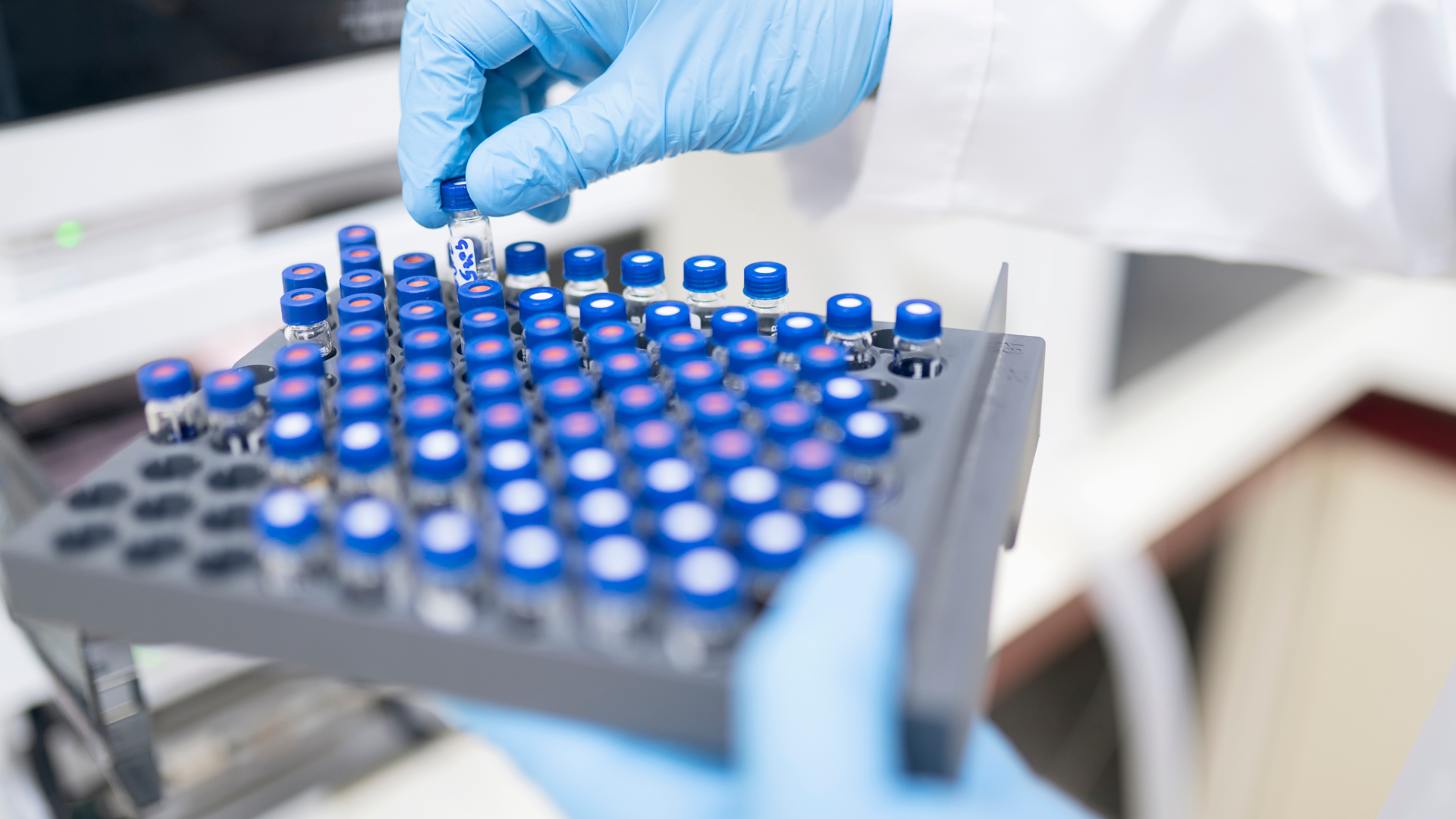 A scientist handling small vials in a lab