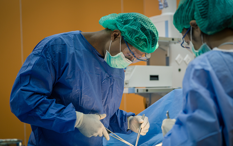 Doctor And Nurse Suture Patient In Emergency Room
