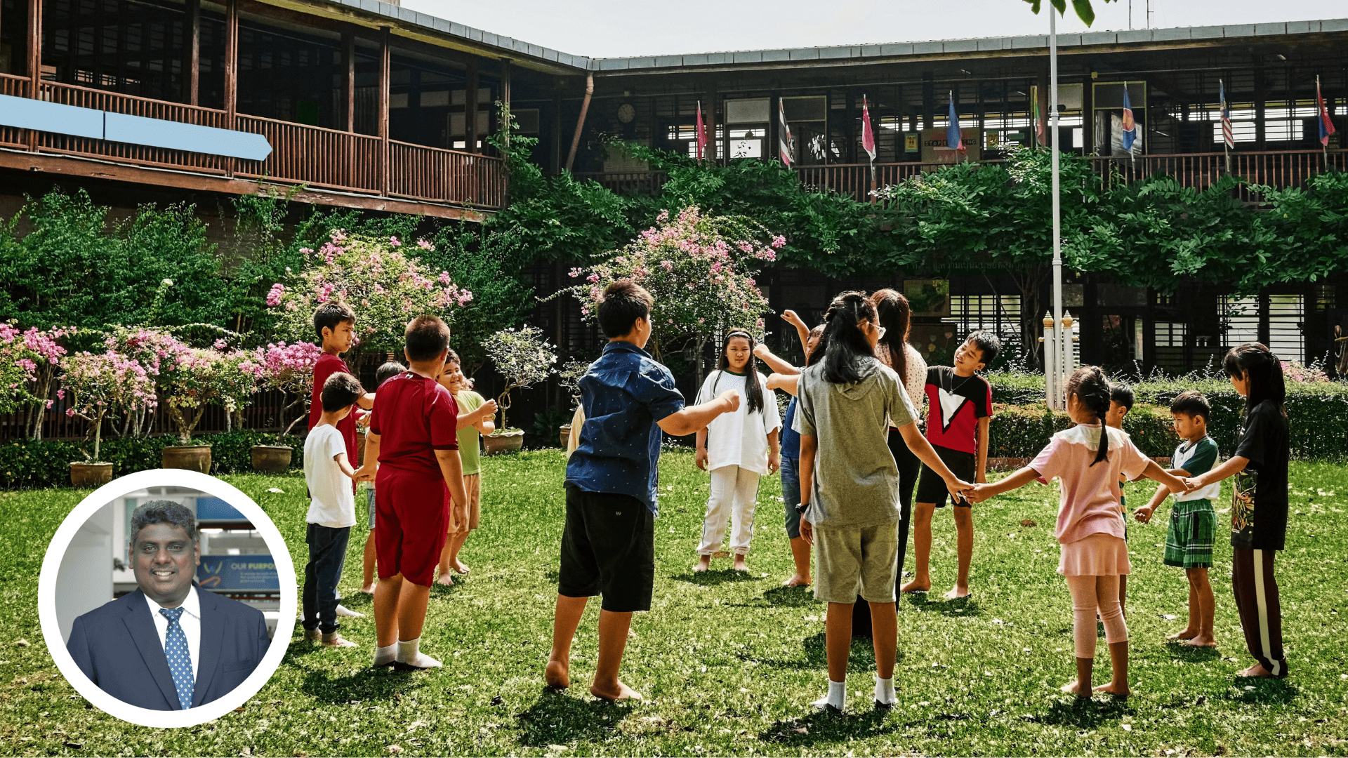 Children standing in circle holding hands enjoying playing with their teacher at a school playground