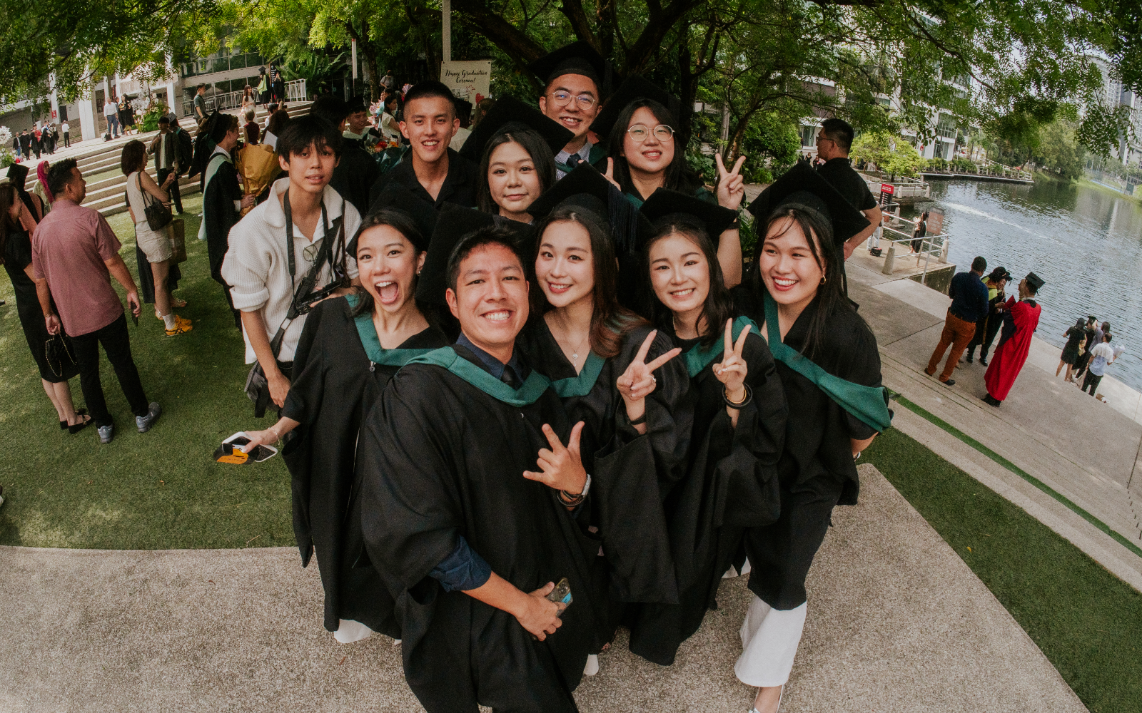It was the day! Group of Taylor's graduates taking photo in front of the lake