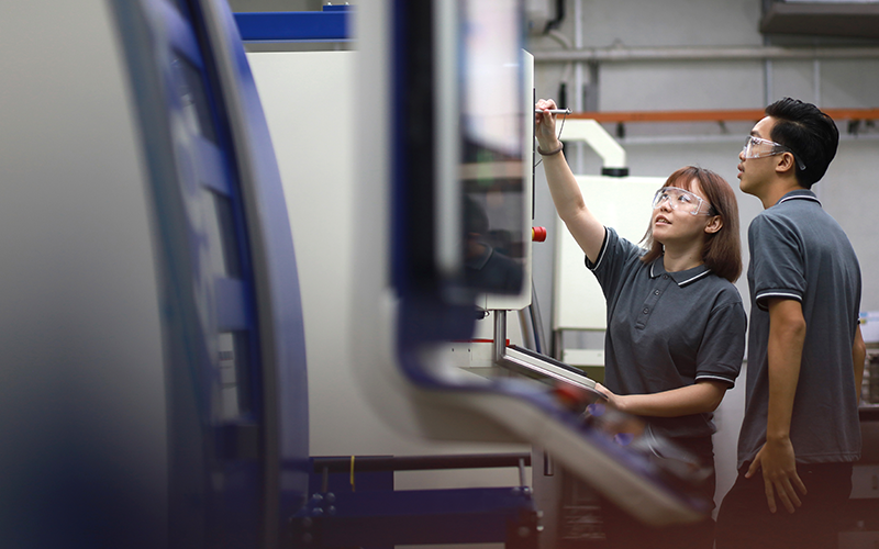 Portrait of Asian Engineers Operating A Machine In Factory