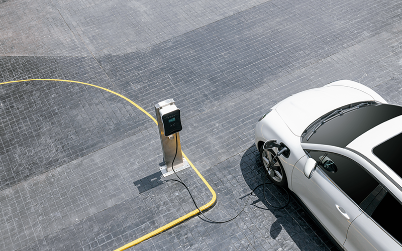 Aerial top view image of progressive green energy-powered charging station, electric vehicle at public car park