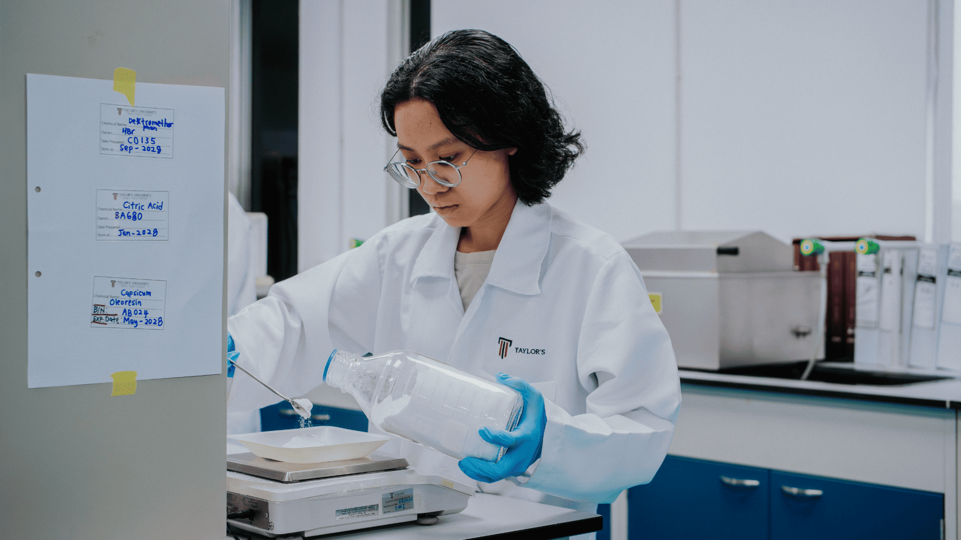 Pharmaceutical science student weighing a compound on a laboratory balance at Taylor's University