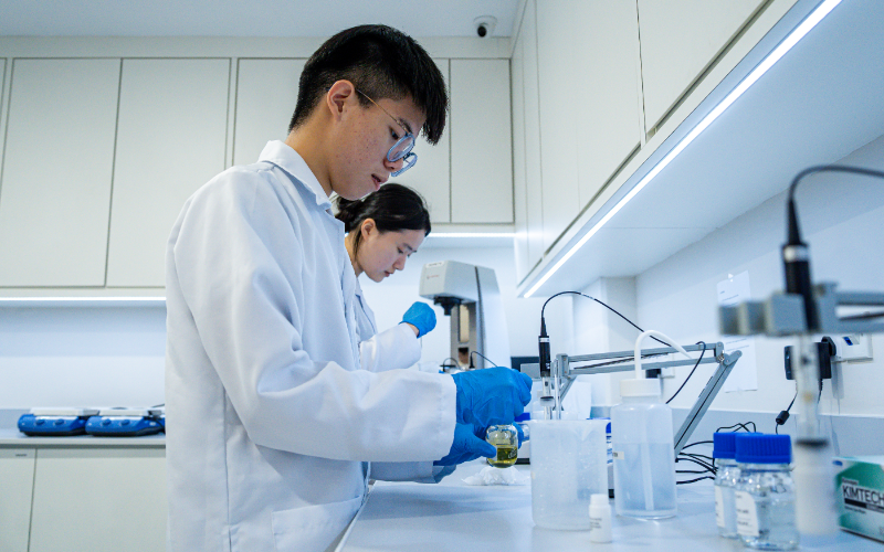 Two students taking an analytical measurement at a laboratory bench