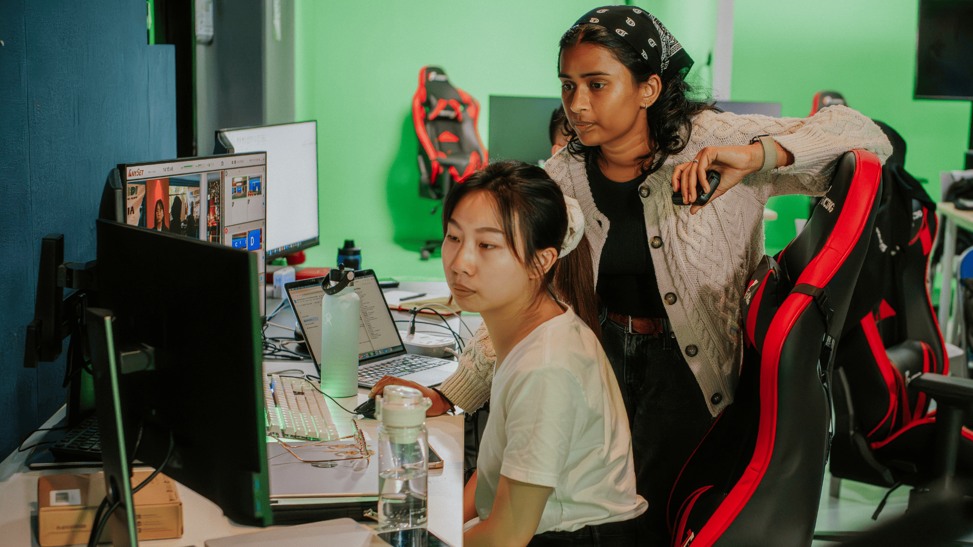 Media and communication students editing footage at a workstation in Taylor's green screen production studio