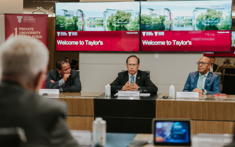 Taylor’s University leaders addressing the MHESC delegation in a meeting room, with a “Welcome to Taylor’s” message displayed on the screens behind them