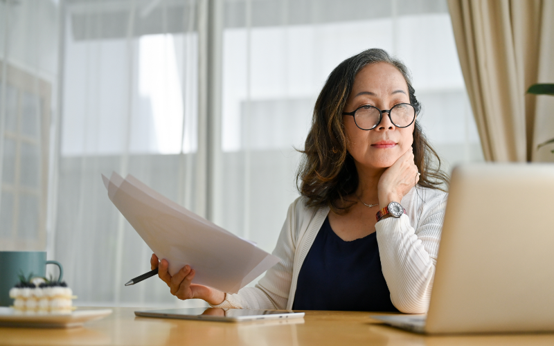 Concentrated asian middle aged female teacher using computer
