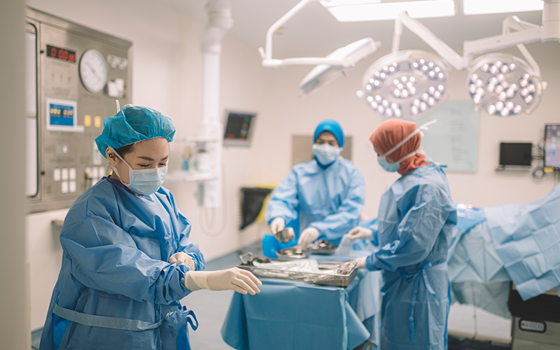 An asian chinese female surgeon doctor is wearing surgical gloves before the surgery in operating room