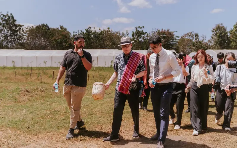 Members of the Taylor's delegation walking through a coffee plantation in Timor-Leste