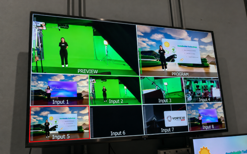 A multiview monitor showing the green-screen preview beside the composited programme output of a presenter in a virtual outdoor scene