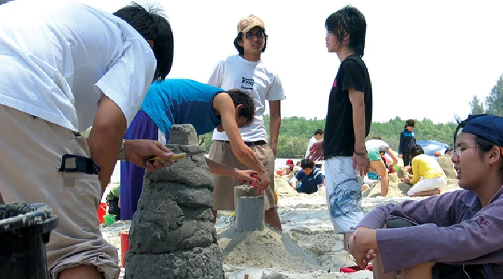 Architecture students using sand as material to build a mock prototype