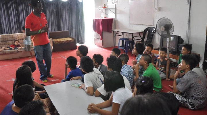  camp leader speaking to kids in a classroom