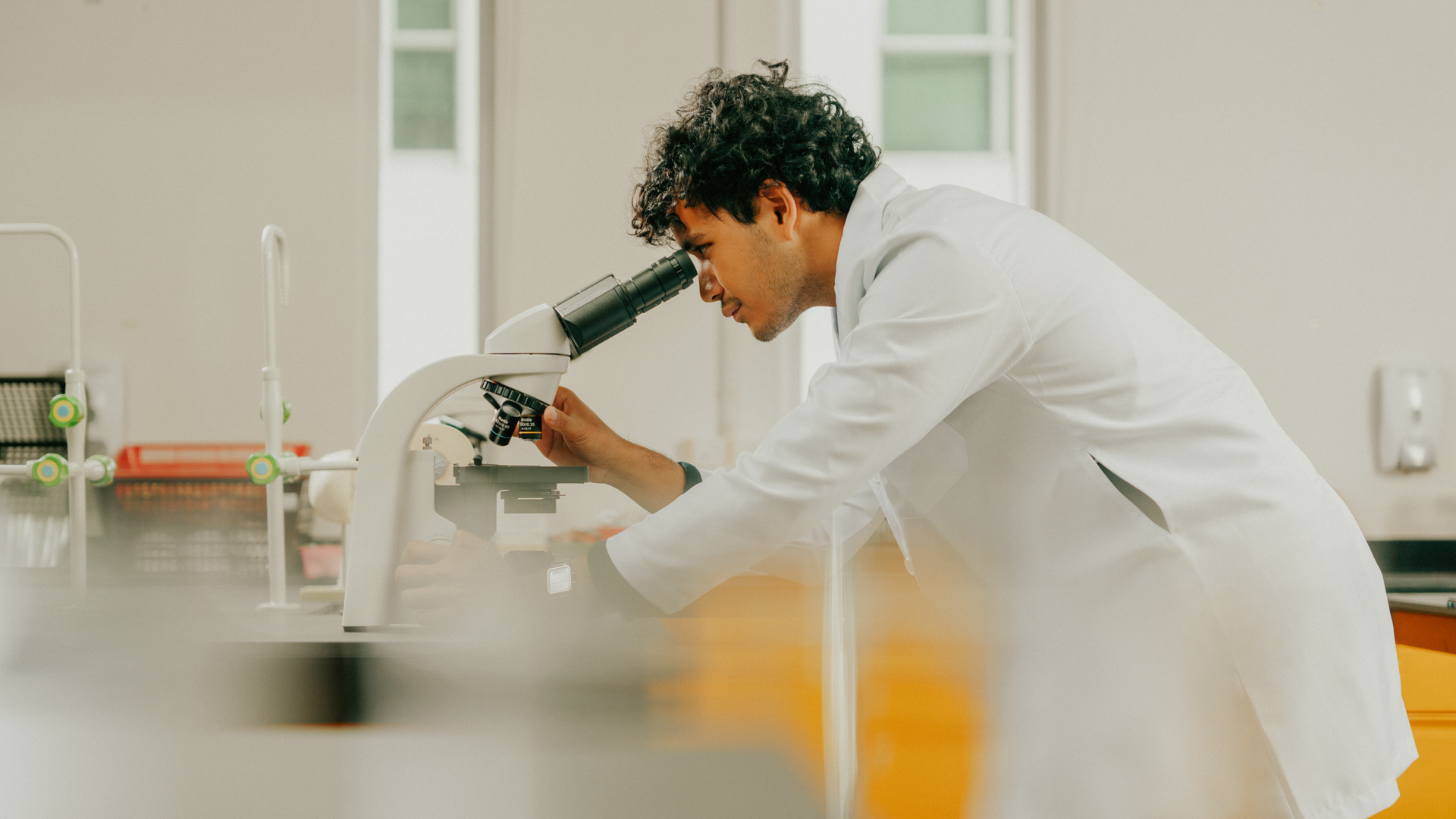 Applied Health Science student using a microscope in a laboratory setting