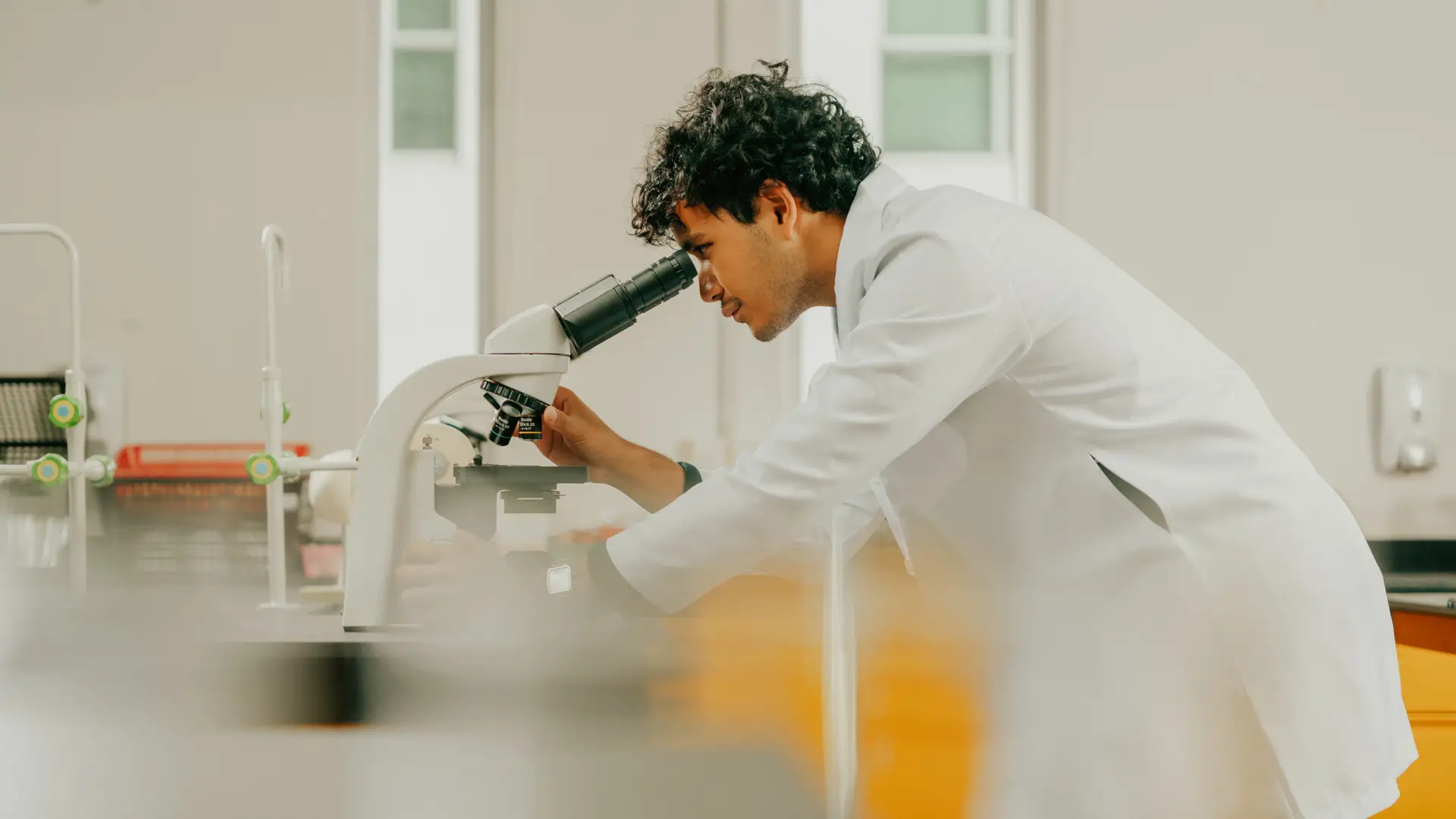 Applied Health Science student using a microscope in a laboratory setting