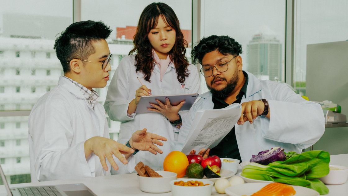 Food science students discussing nutrition research with fresh ingredients in a laboratory setting