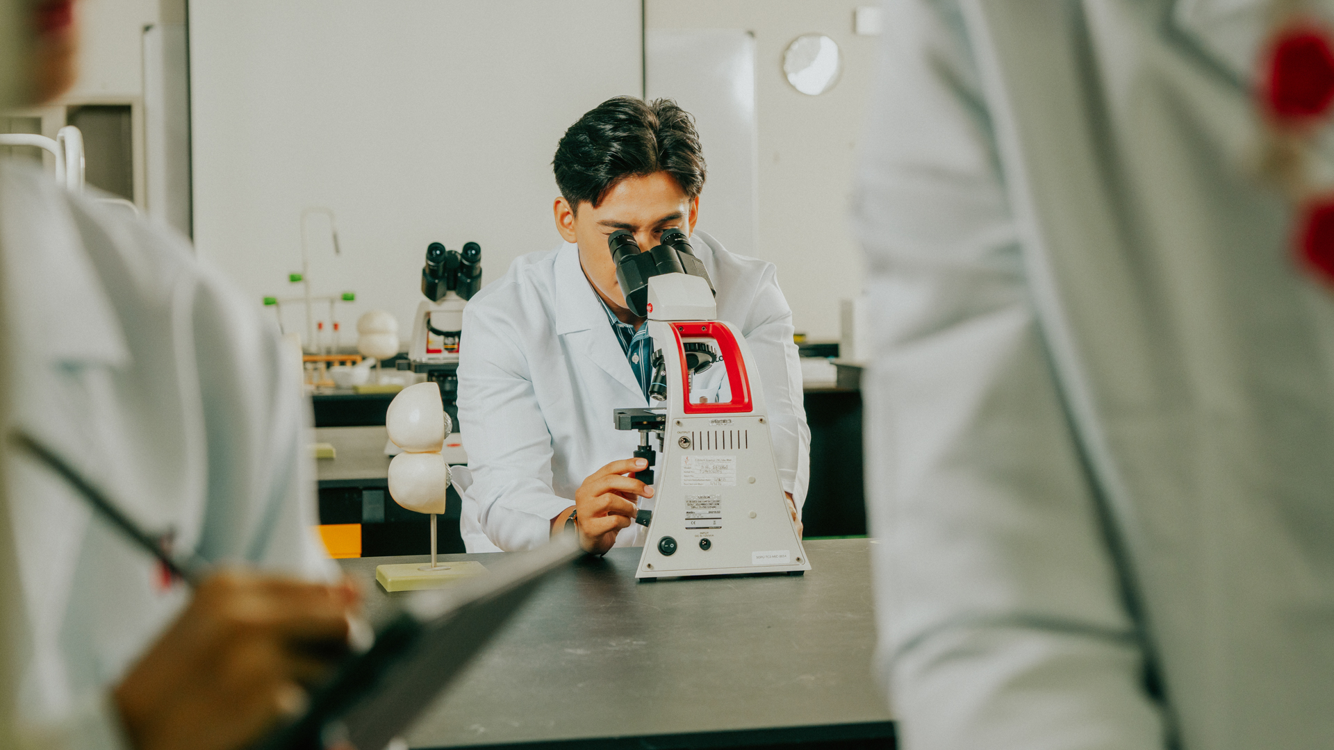 Biomedical science student using a microscope in a laboratory setting