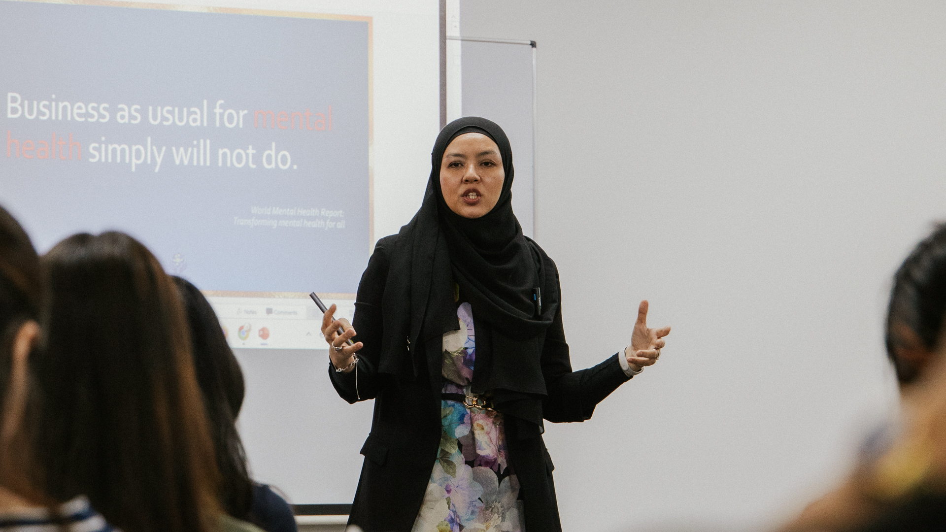 PhD in Business candidate delivering a presentation in a professional classroom setting