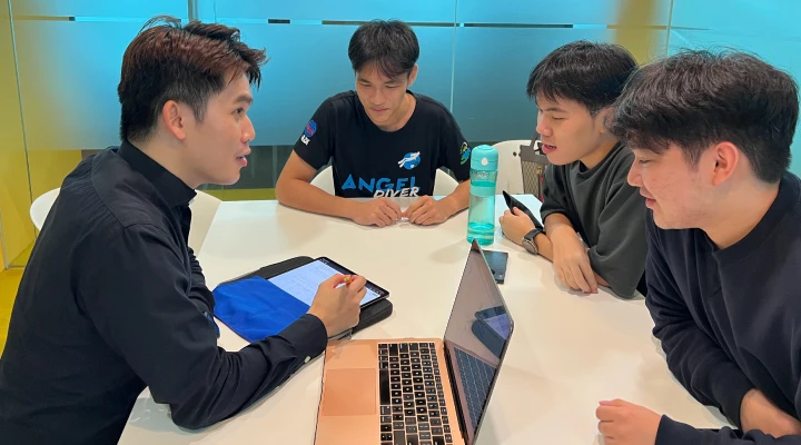 Group of 3 students with lecturer discussing on the business study plan