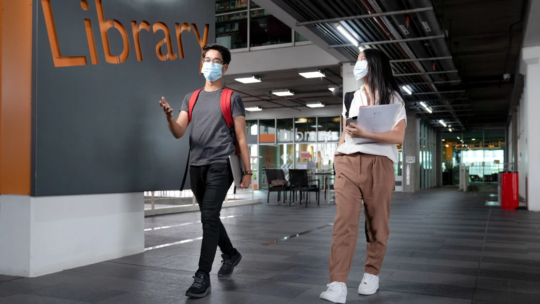 Taylor's student walking toward the entrance of library