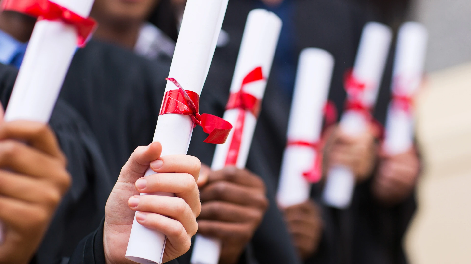 Taylor's computing student holding the graduation scroll