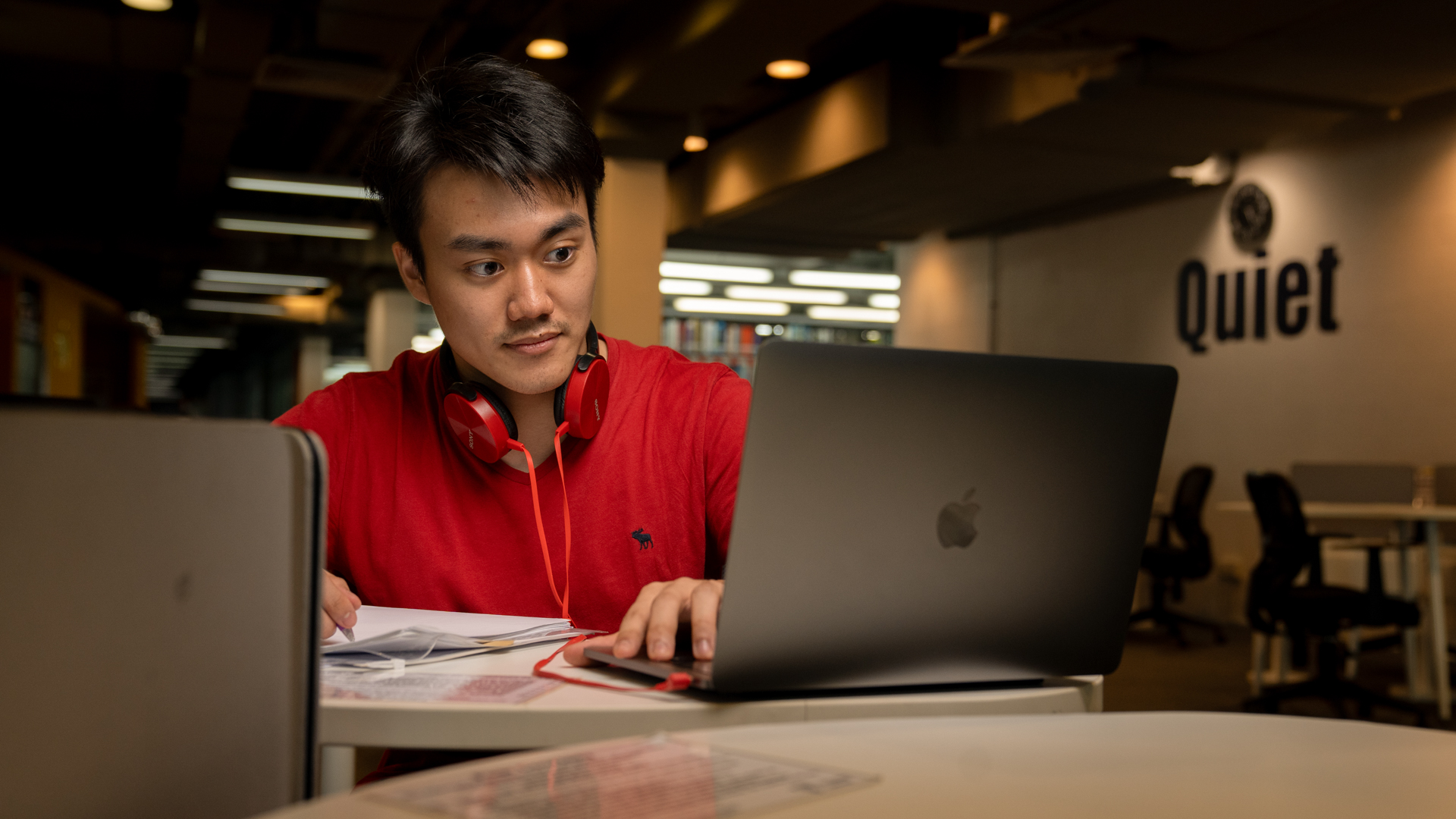 Taylor's information technology student working on assignment on laptop
