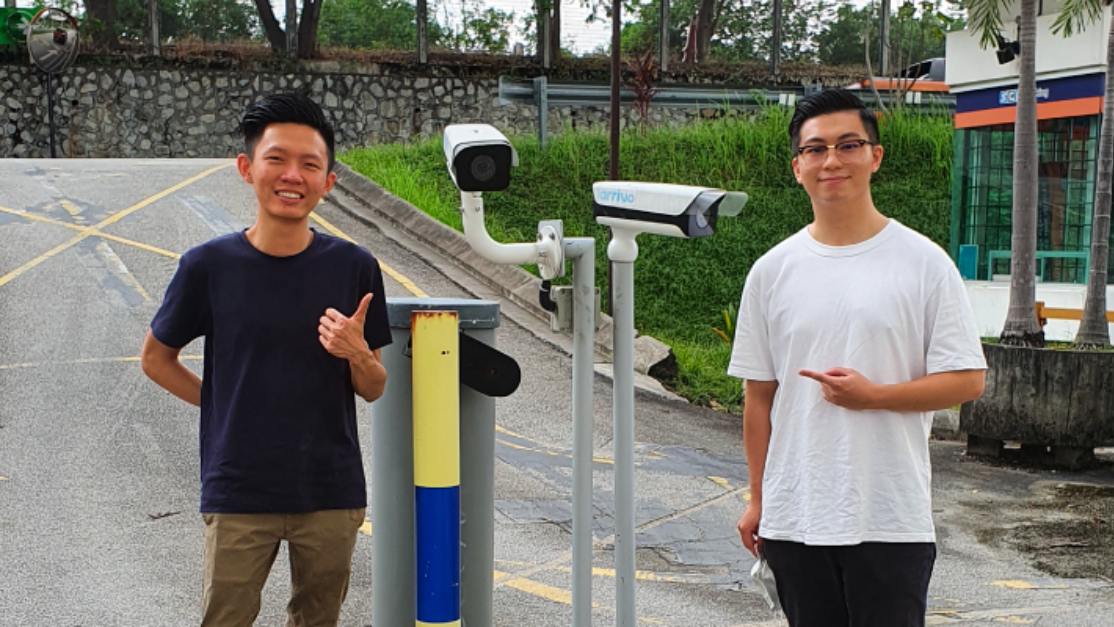 Two students standing in front of the gate barrier control