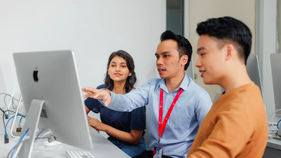 Lecturer guiding student on setting up a website for his business