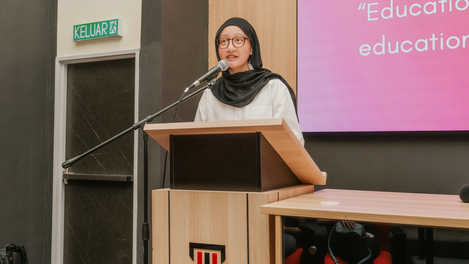 Education student delivering a presentation at a podium during an academic seminar
