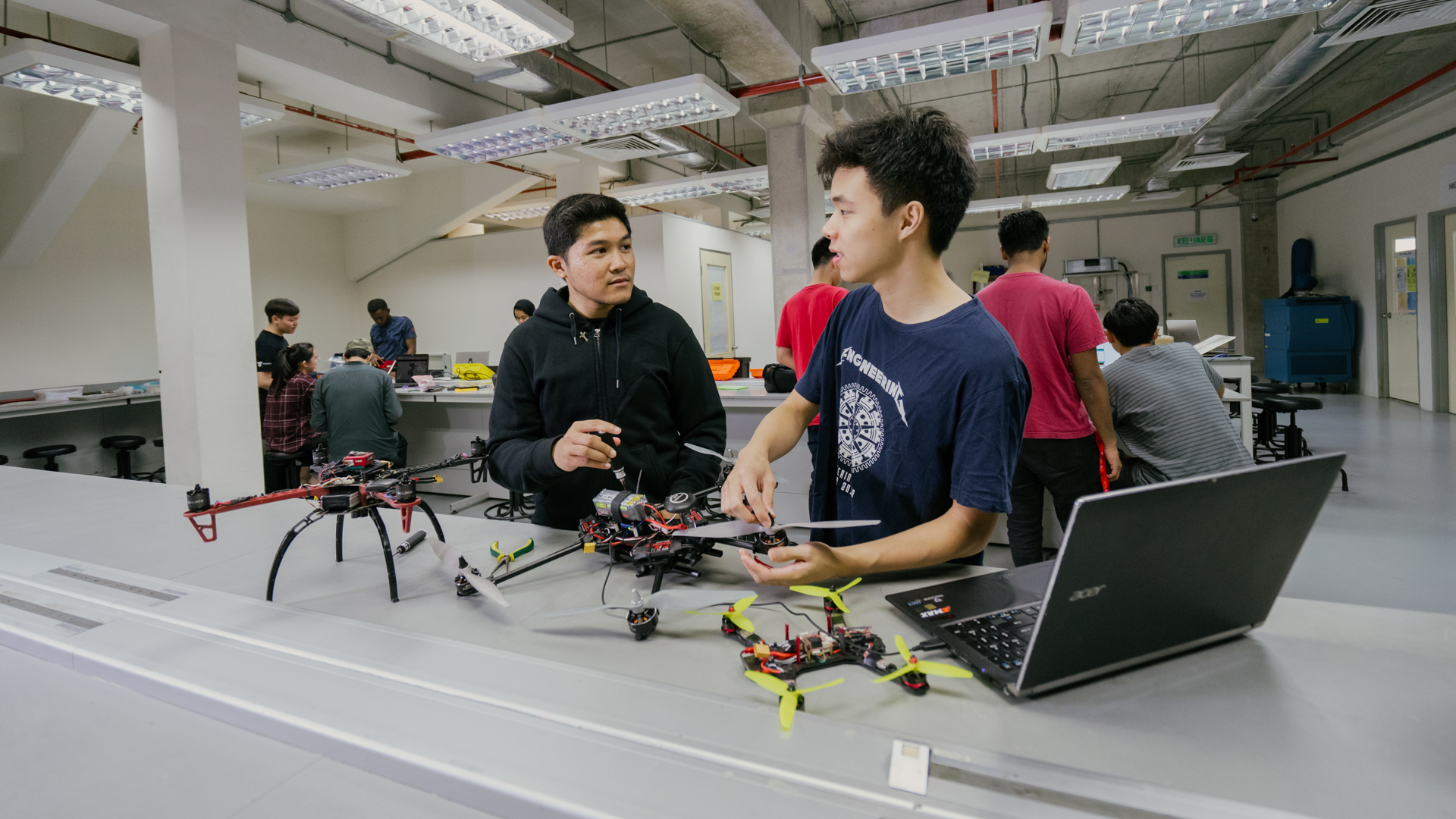 Master of Science in Engineering students collaborating on drone and robotics projects in an engineering lab