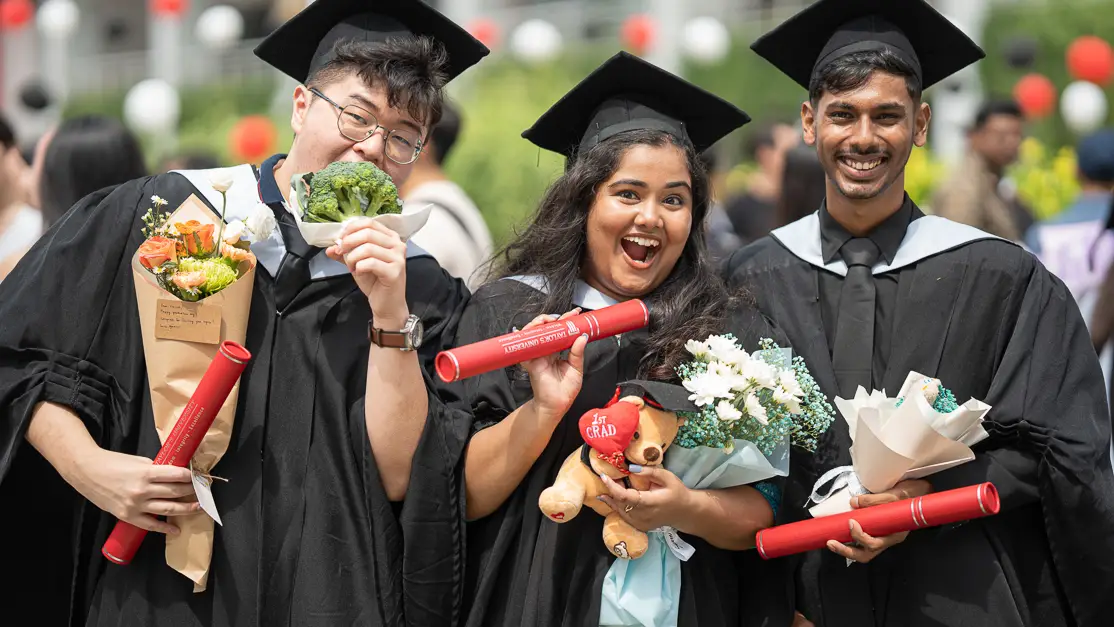 Taylor's culinary student holding graduation scroll with peers