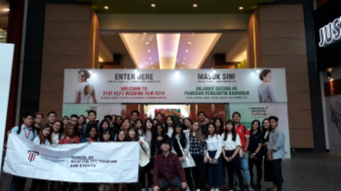 group picture of students in front of the entrance of a wedding fair
