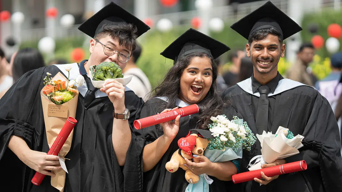 Taylor's hospitality student holding graduation scroll with peers