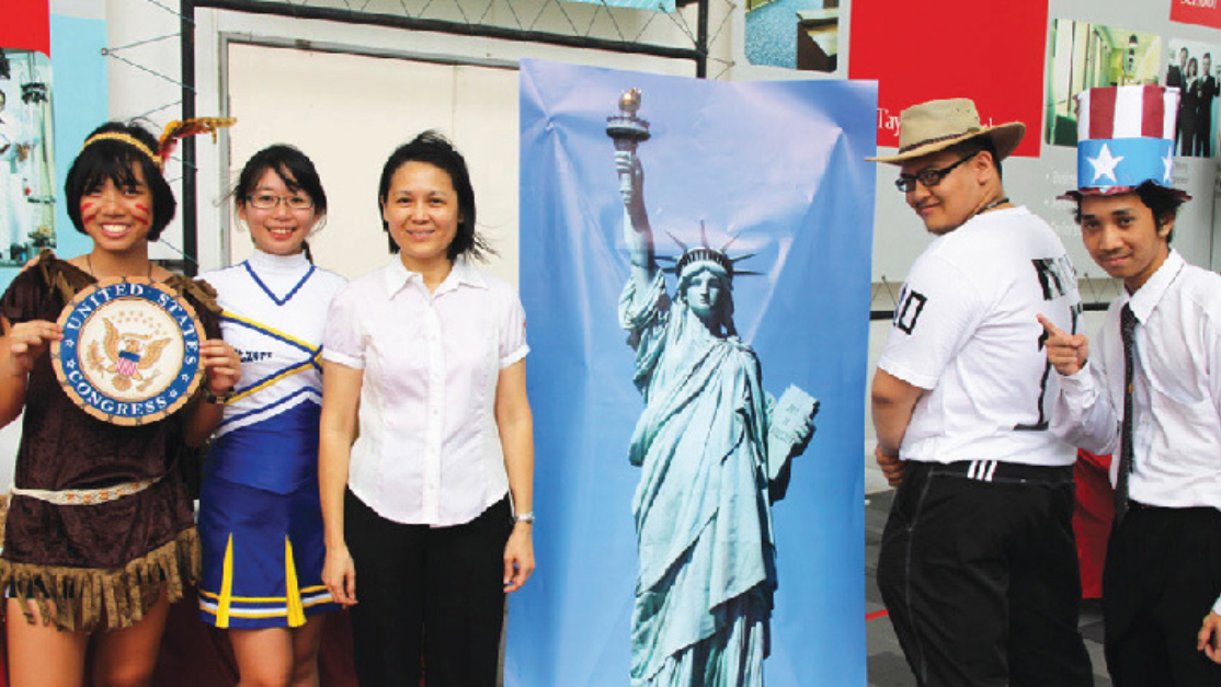 students posing beside bunting of the statue of liberty