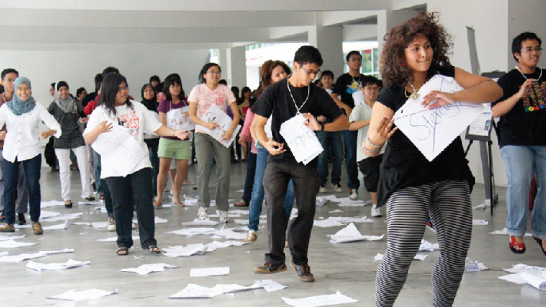students lined up while holding paper in front of them