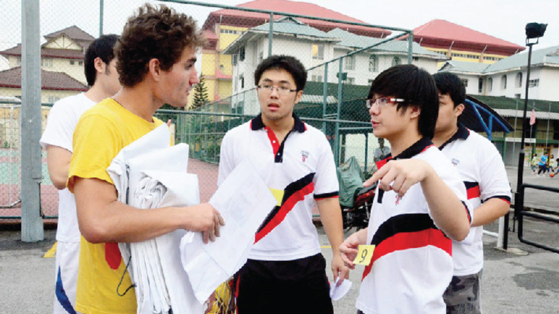 group of students approaching a caucasian young man