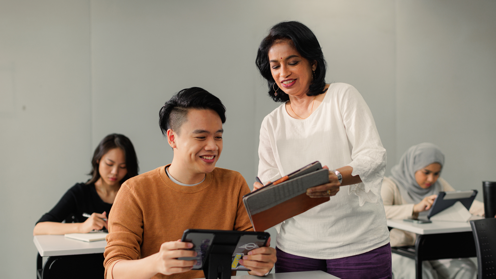 Lecturer consulting a student with a smile