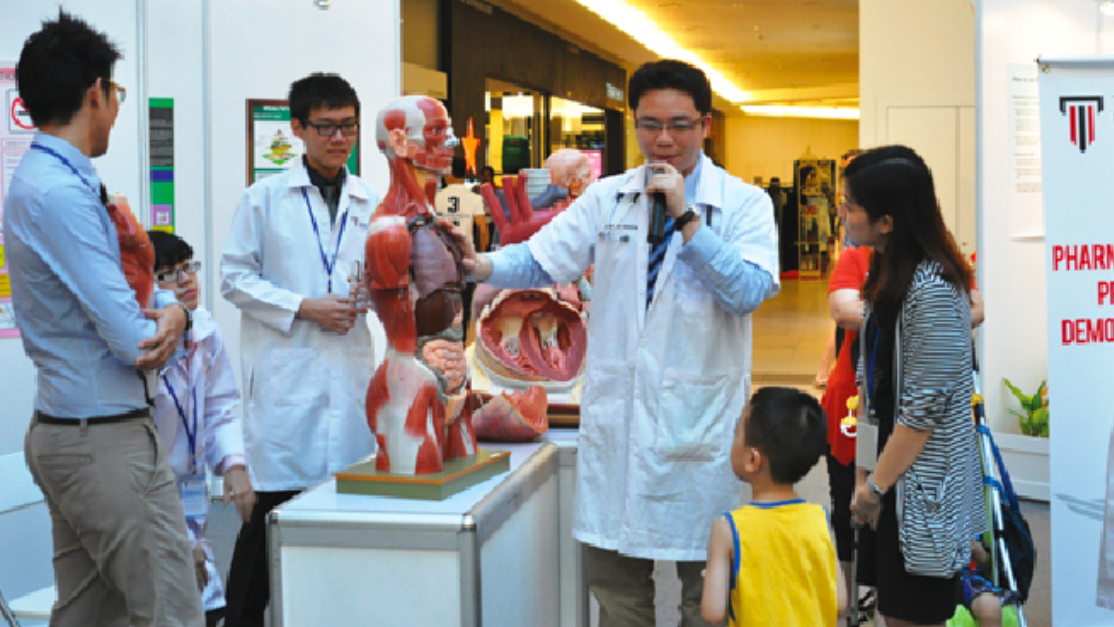 Student demonstrate poster to a pass-by