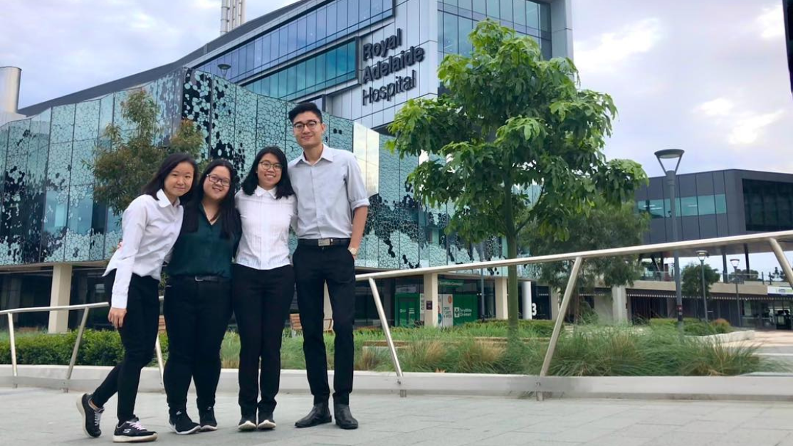 Four Taylor's Pharmacy Student's taking photos in front of the main entrance for UNISA