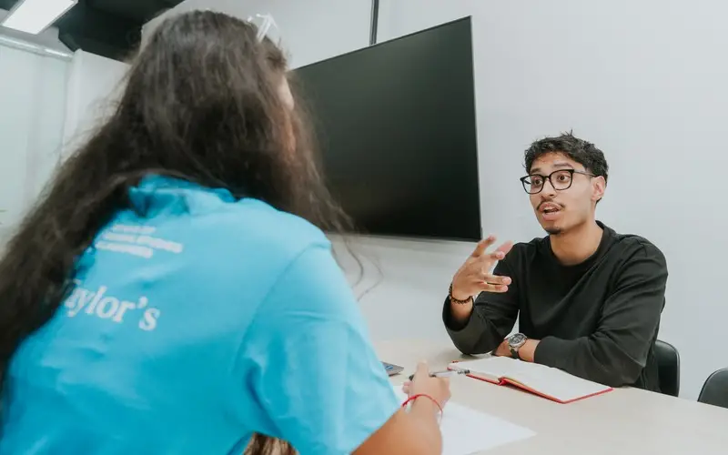 A student rehearses his explanation while a peer coach listens