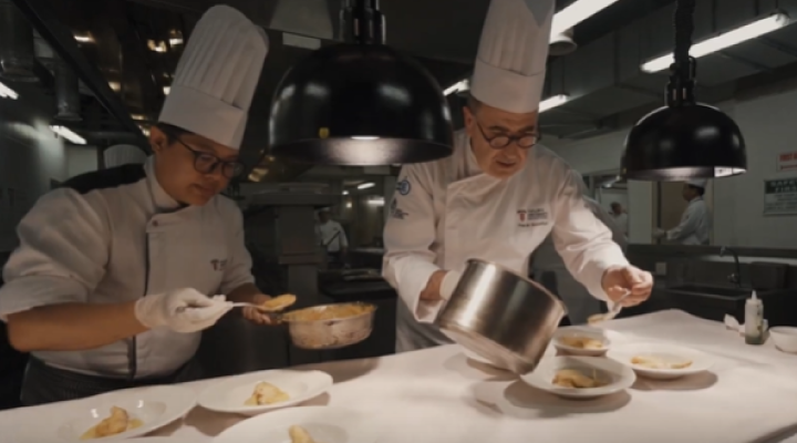 a team of students at the kitchen station plating food