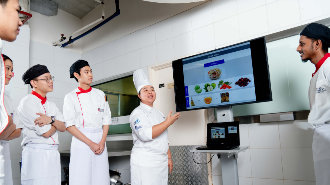 Lecturer teaching students using a large monitor