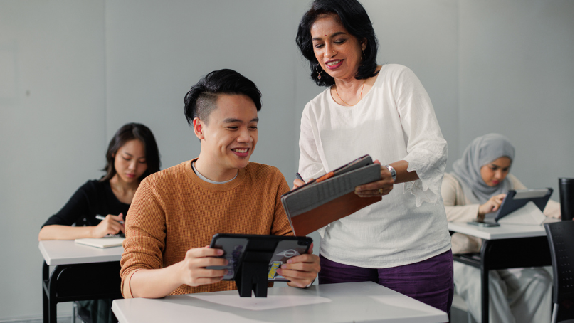 teacher teaching a student with an ipad