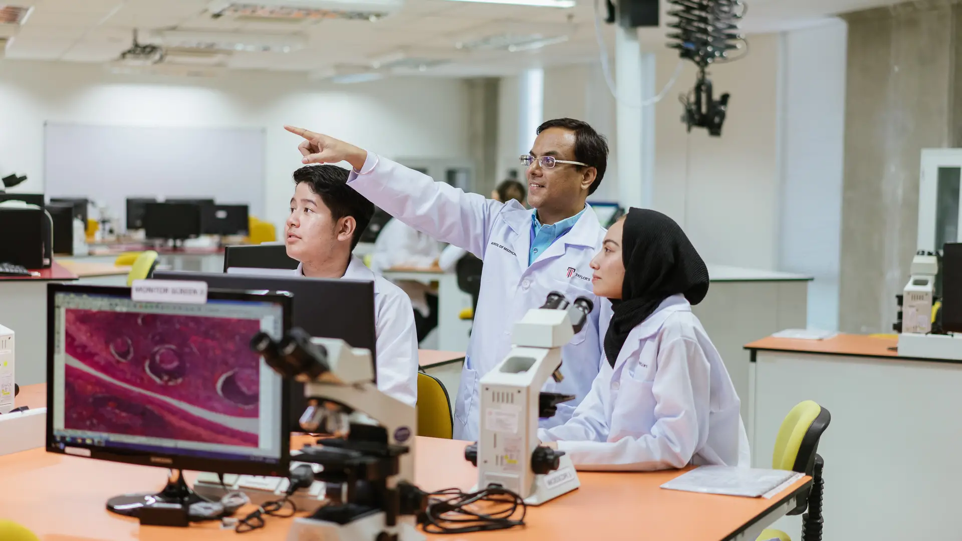 Taylor's lecturer and students in the laboratory